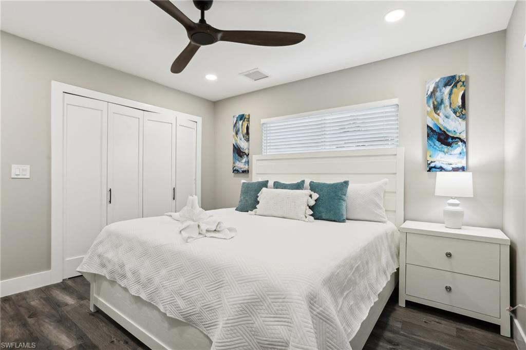 Bedroom with a closet, ceiling fan, and dark wood-type flooring