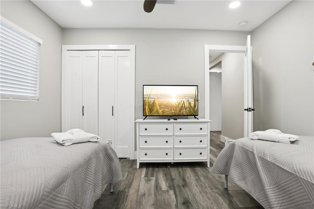 Bedroom featuring dark wood-type flooring, ceiling fan, and a closet