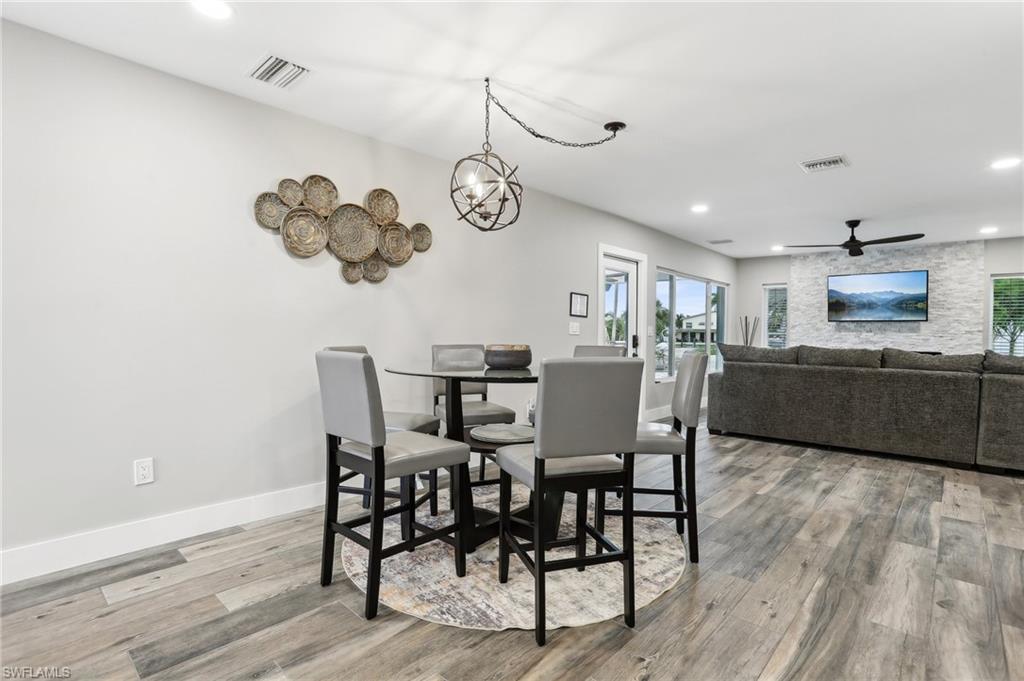 Dining space featuring ceiling fan with notable chandelier and hardwood / wood-style floors