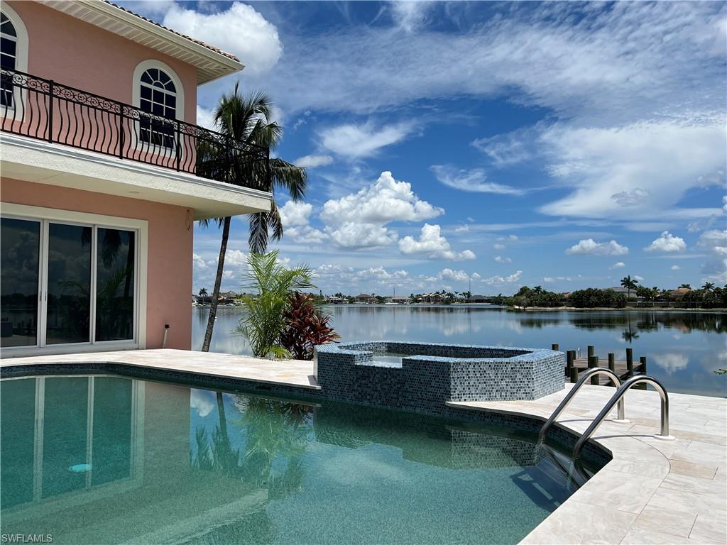 View of pool featuring an in ground hot tub and a lake view