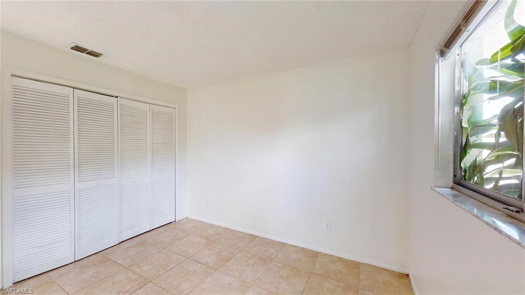 Unfurnished bedroom featuring a closet and light tile patterned floors