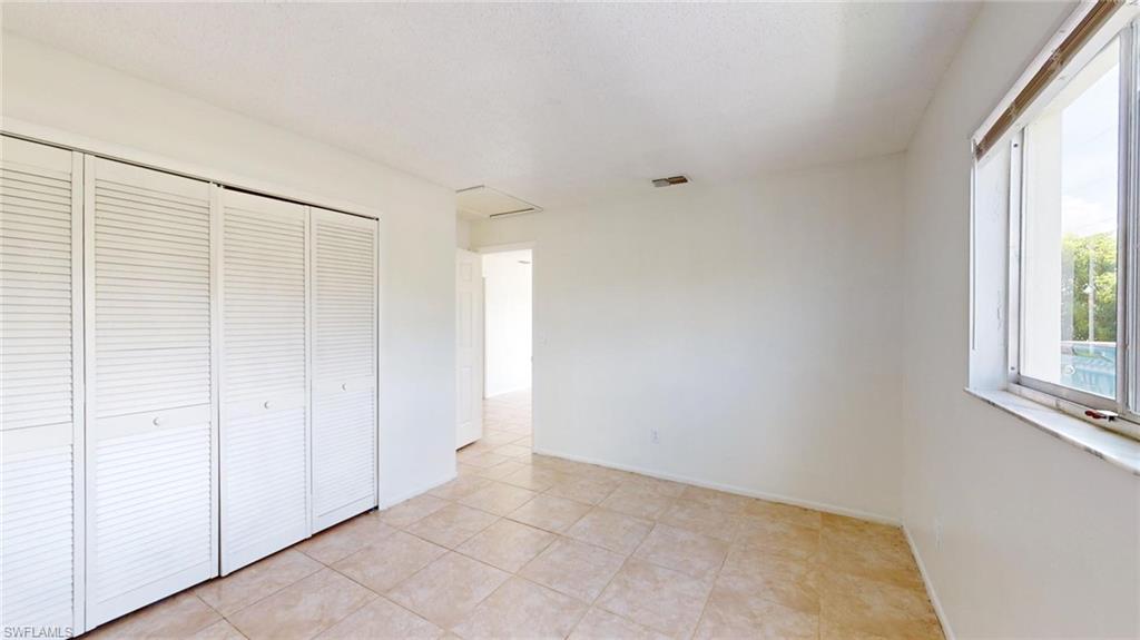 Unfurnished bedroom with light tile patterned flooring and a closet