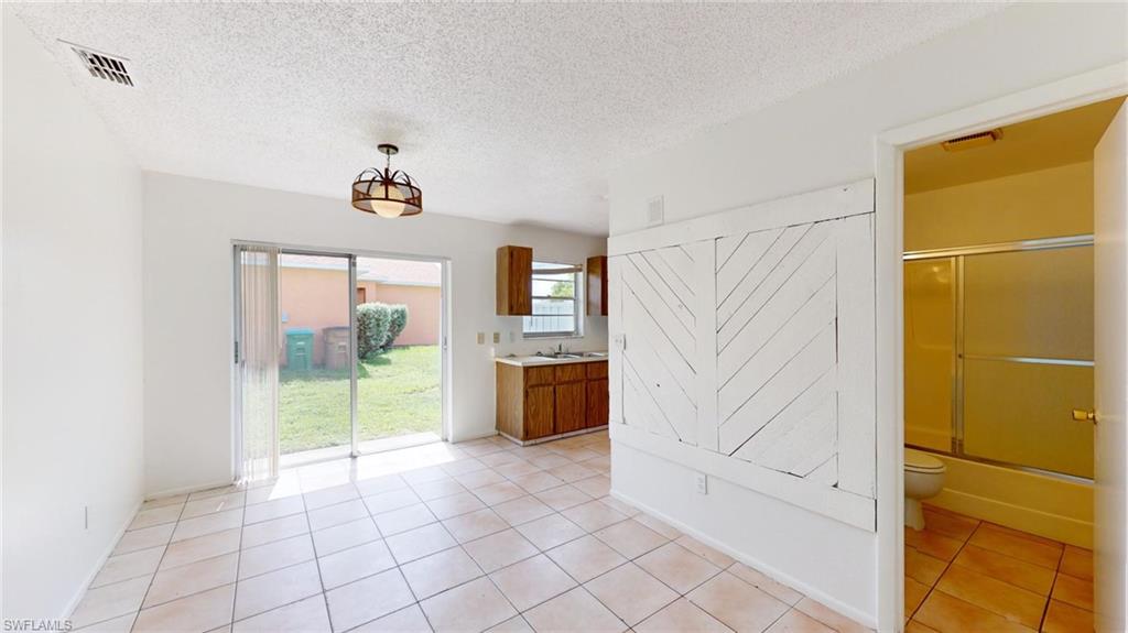 Spare room with light tile patterned floors and a textured ceiling