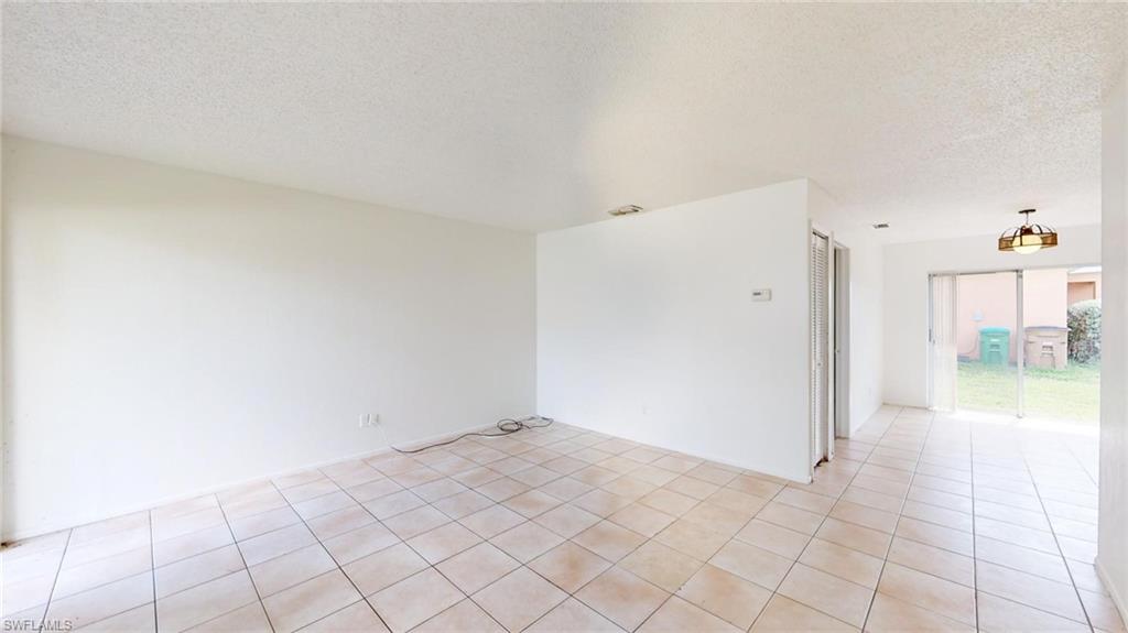 Spare room with a textured ceiling and light tile patterned floors