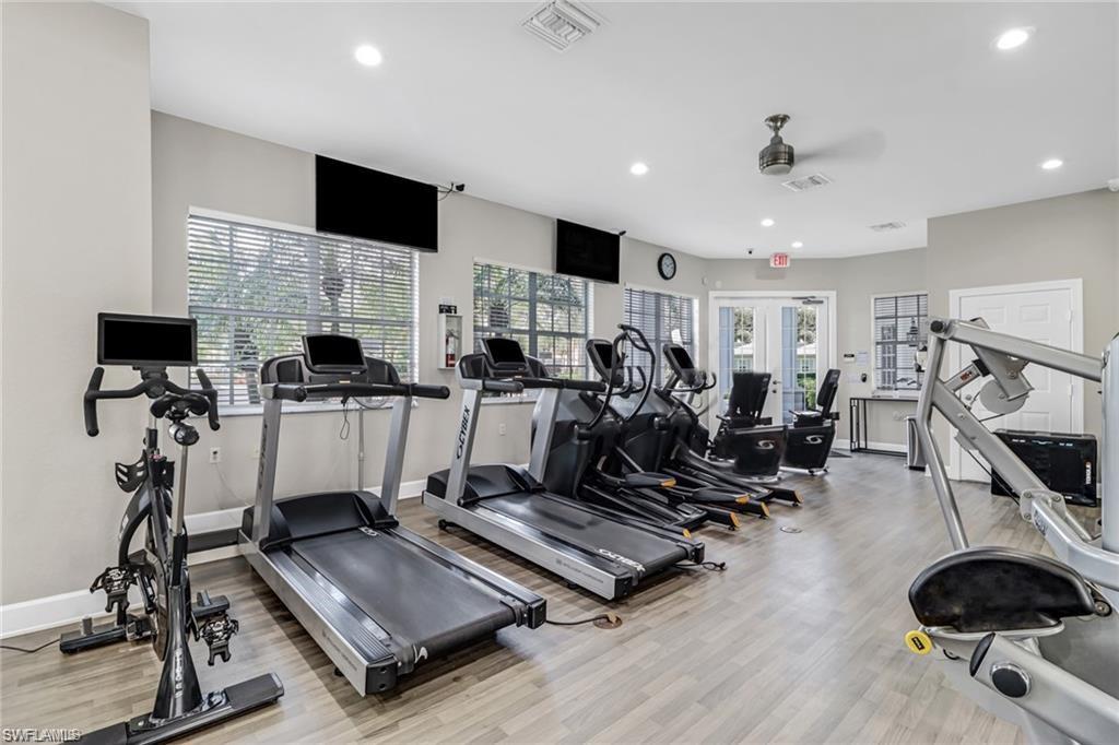 Exercise room with french doors, a wealth of natural light, ceiling fan, and light wood-type flooring