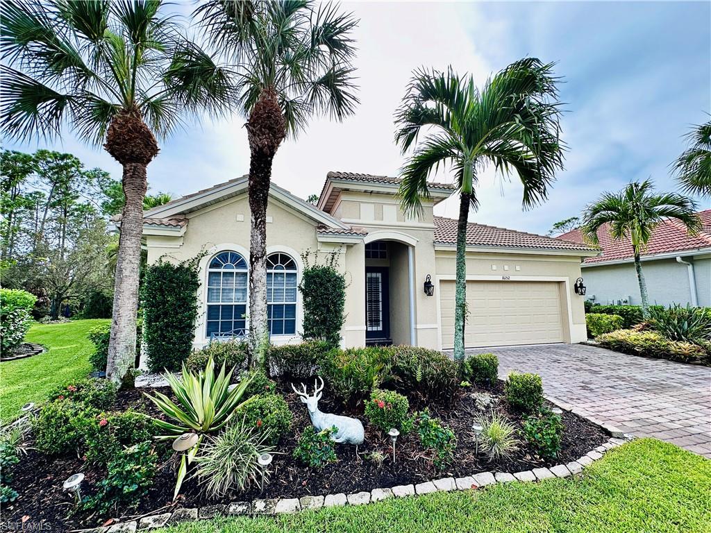 View of front of house with a garage and a front yard