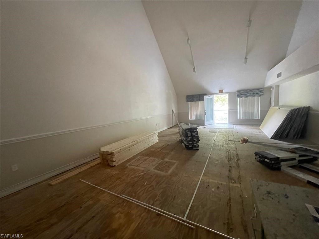 Bonus room with vaulted ceiling and dark wood-type flooring