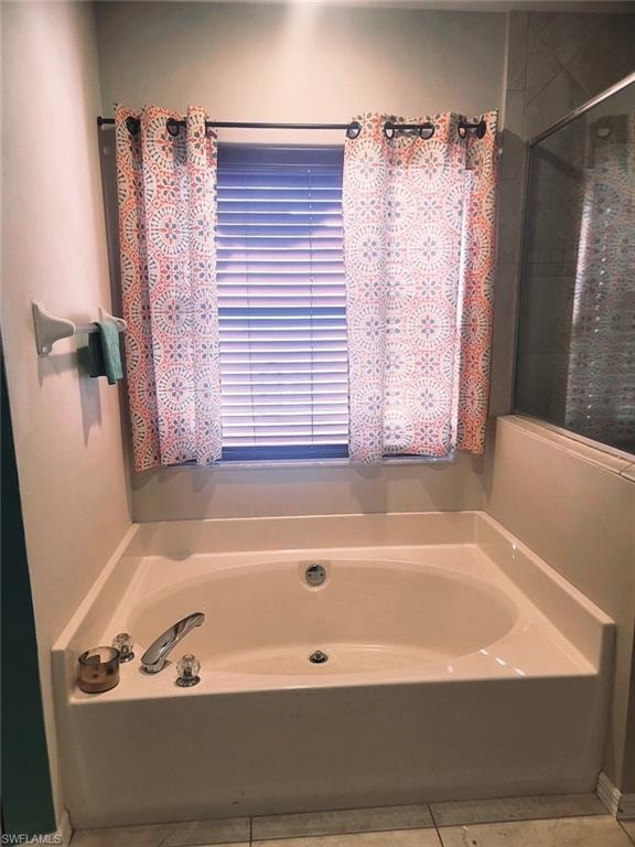Bathroom featuring tile patterned floors and a tub to relax in