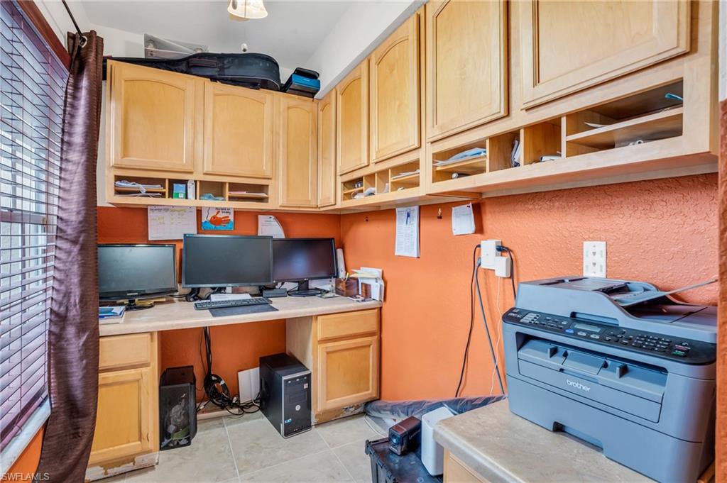 Office area featuring light tile patterned floors and built in desk
