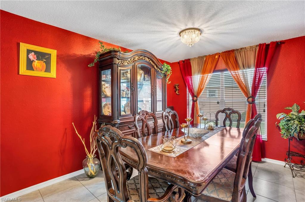 Dining area with light tile patterned flooring and a textured ceiling