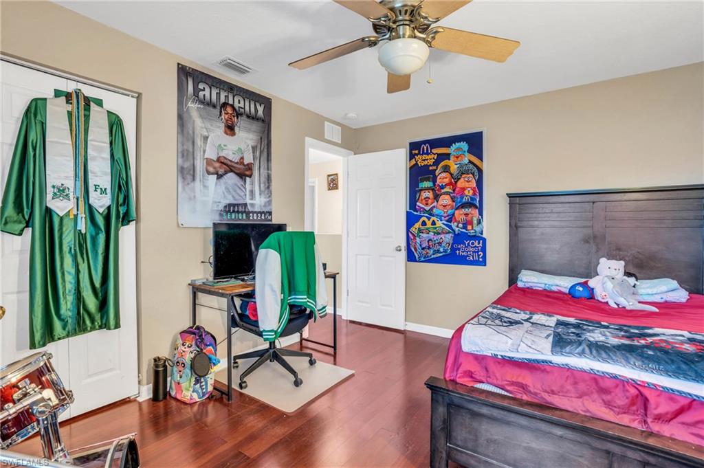 Bedroom with ceiling fan, a closet, and hardwood / wood-style flooring