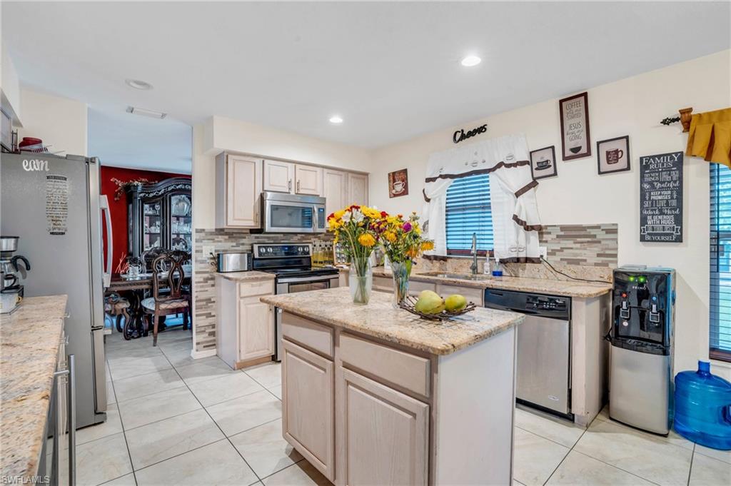 Kitchen featuring tasteful backsplash, stainless steel appliances, and a kitchen island