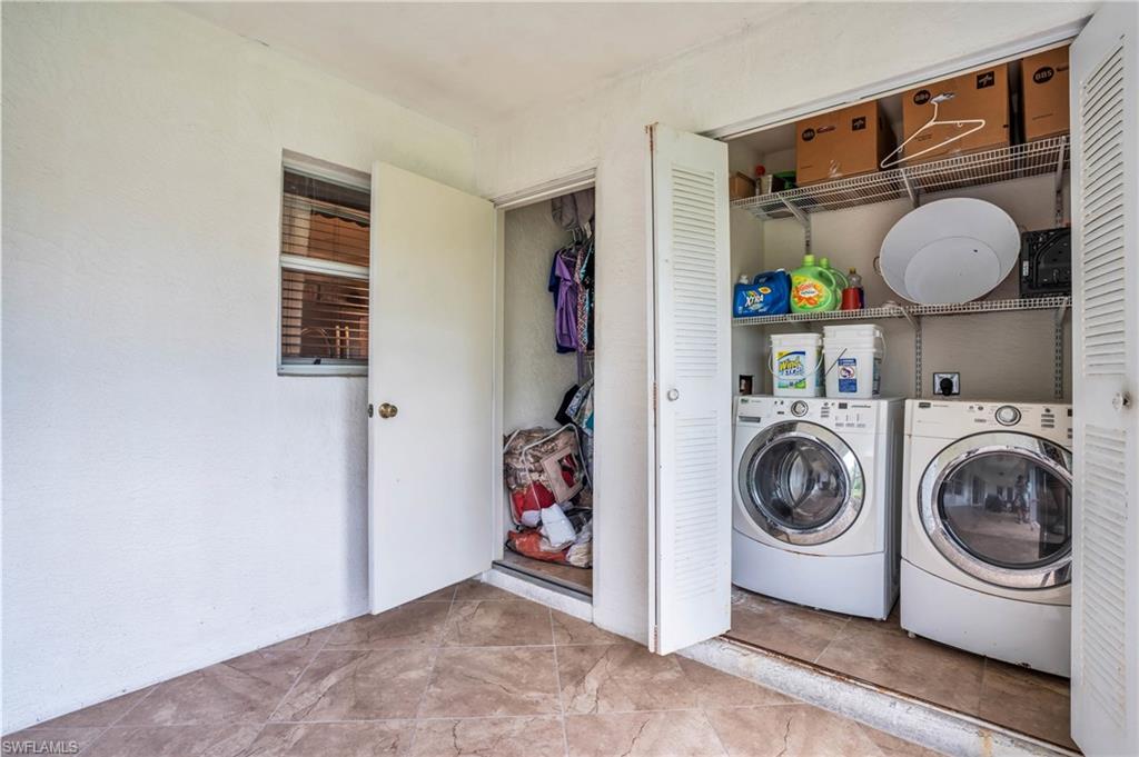 Laundry room with light tile patterned floors and independent washer and dryer