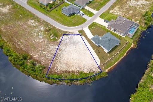 Birds eye view of property with a water view