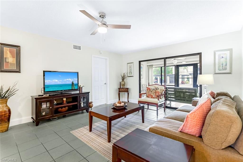 Living room featuring ceiling fan and tile patterned floors