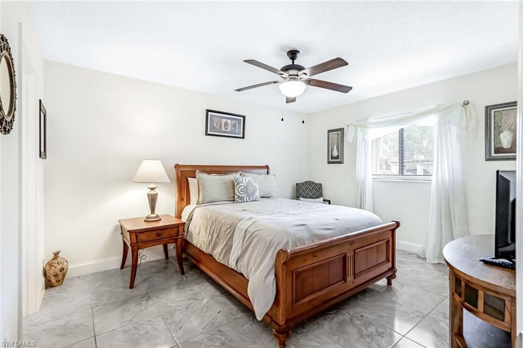 Bedroom with ceiling fan and light tile patterned floors