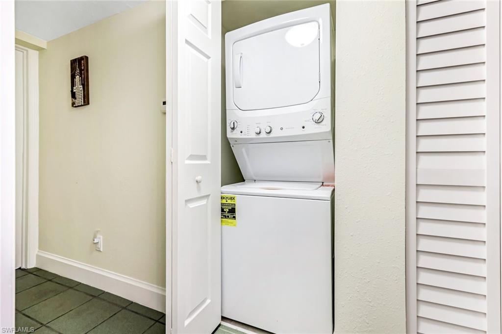 Laundry area featuring stacked washer and dryer and tile patterned floors