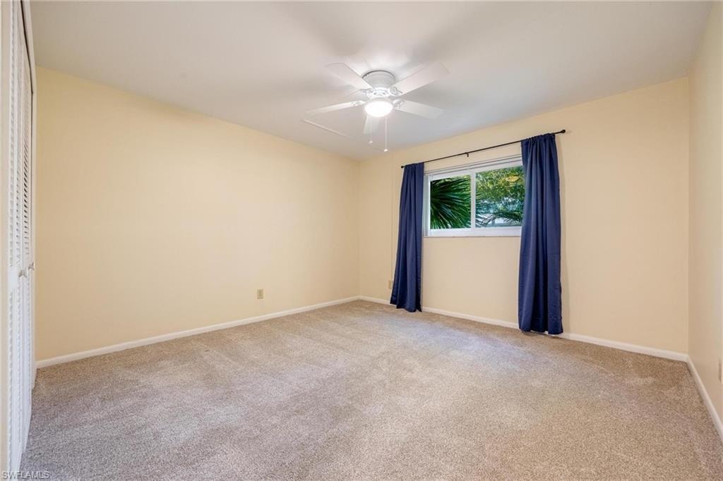 Bedroom with ceiling fan and light colored carpet