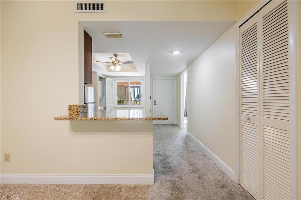 Kitchen peninsula and light colored carpet.