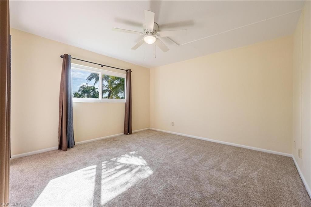 Carpeted Primary Bedroom featuring ceiling fan