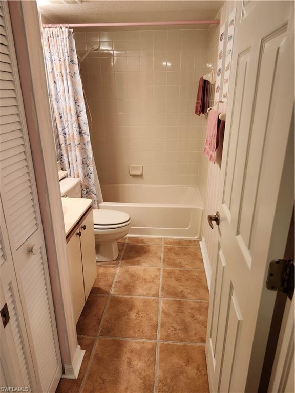 Full bathroom featuring tile patterned floors, toilet, shower / tub combo with curtain, and vanity
