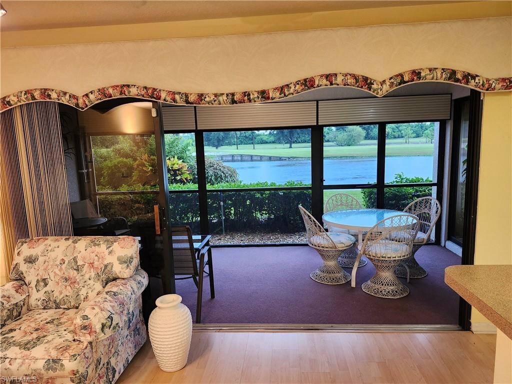 Living room with hardwood / wood-style floors and a water view