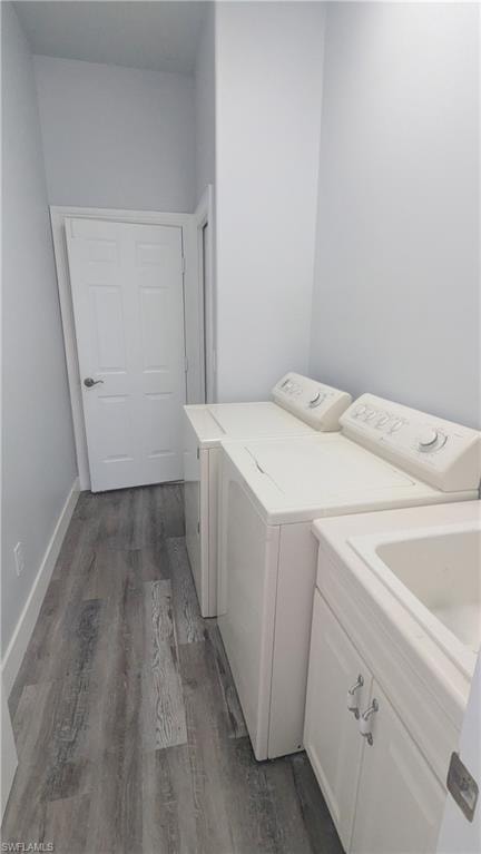 Washroom featuring dark wood-type flooring, cabinets, and independent washer and dryer