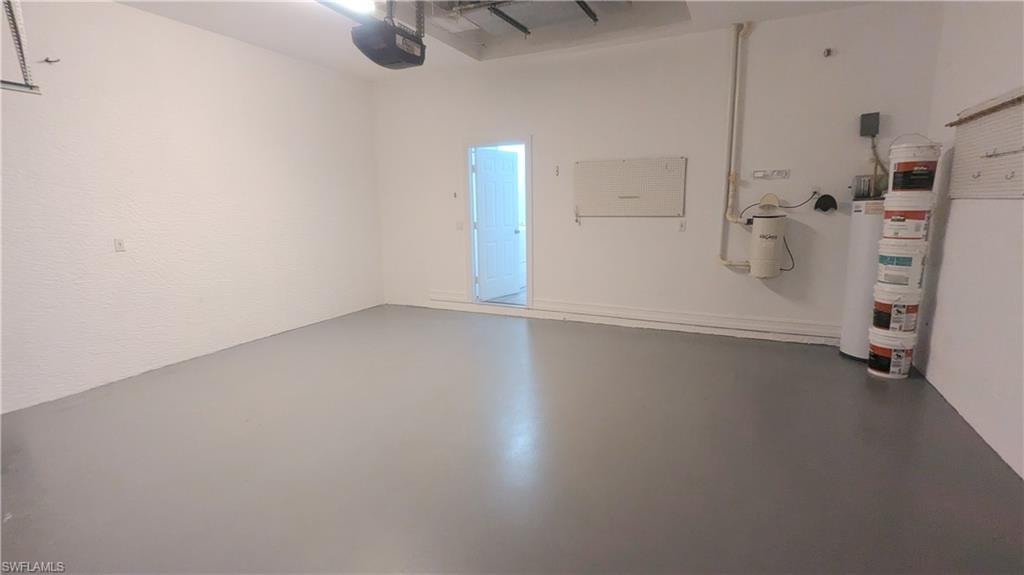 Garage featuring a garage door opener and water heater