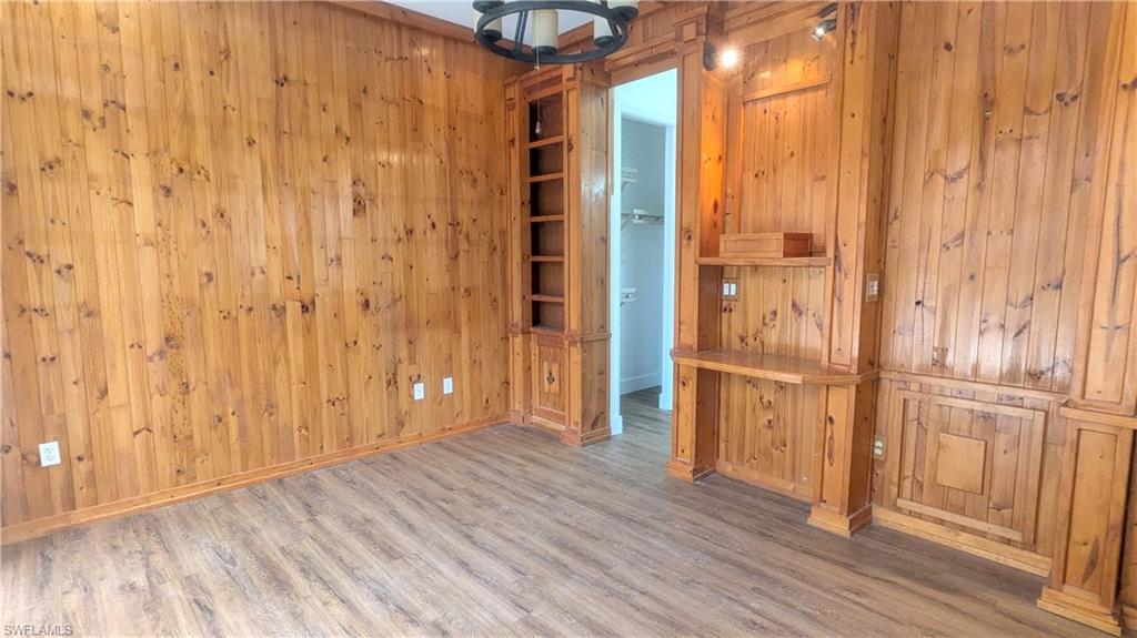 Unfurnished room with wood walls and light hardwood / wood-style flooring
