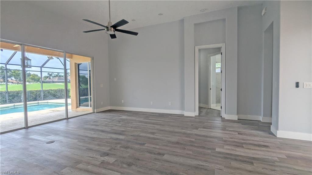 Unfurnished room with high vaulted ceiling, ceiling fan, and wood-type flooring