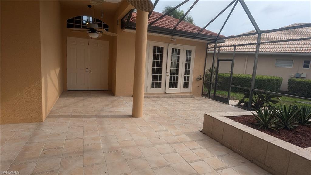 View of patio / terrace with glass enclosure, ceiling fan, and french doors