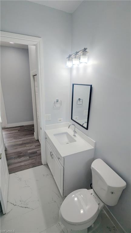 Bathroom with toilet, hardwood / wood-style flooring, and vanity
