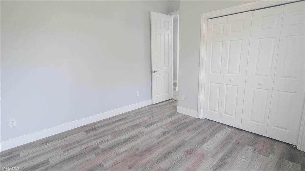 Unfurnished bedroom featuring light hardwood / wood-style flooring and a closet