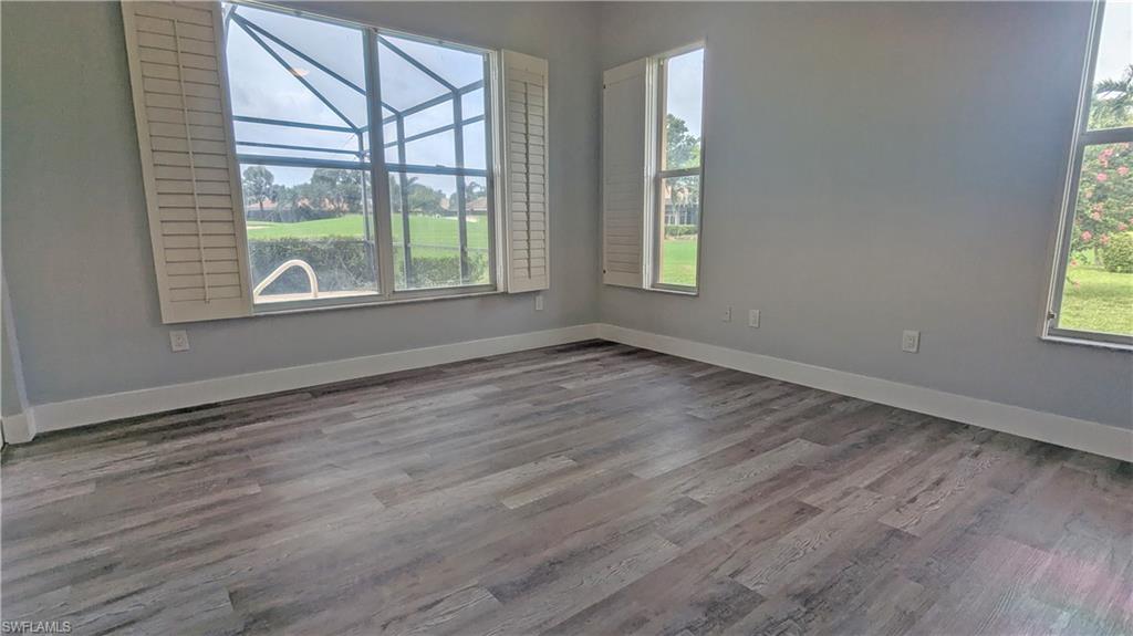 Unfurnished room with a healthy amount of sunlight and hardwood / wood-style flooring
