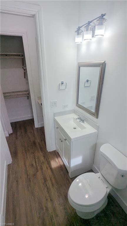 Bathroom featuring hardwood / wood-style floors, toilet, and vanity