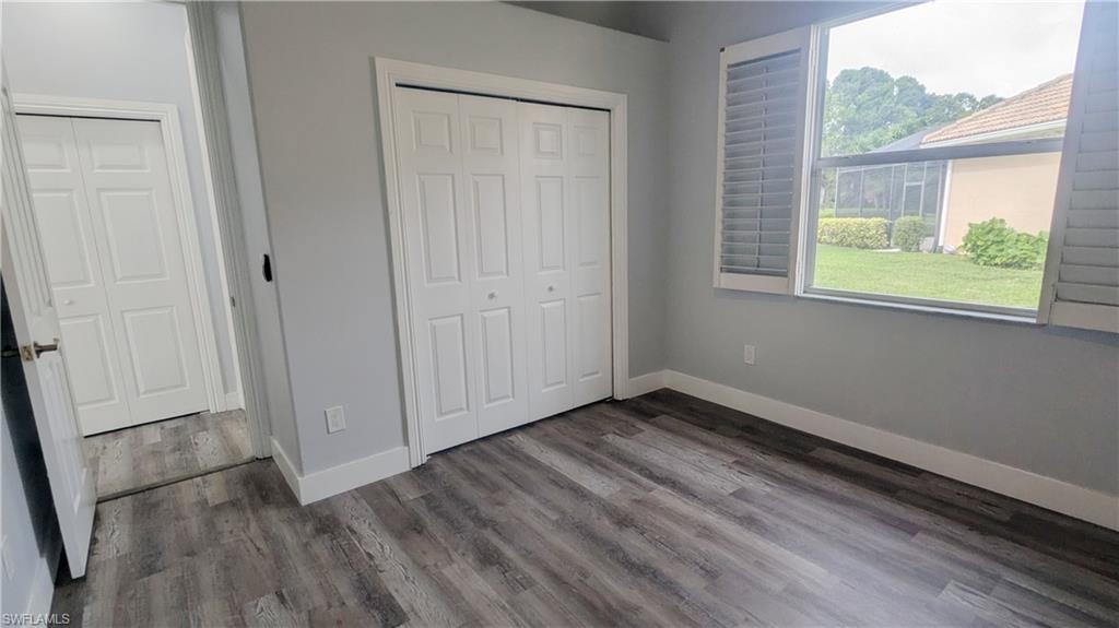 Unfurnished bedroom with dark hardwood / wood-style flooring