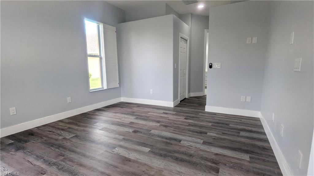 Empty room featuring dark hardwood / wood-style floors