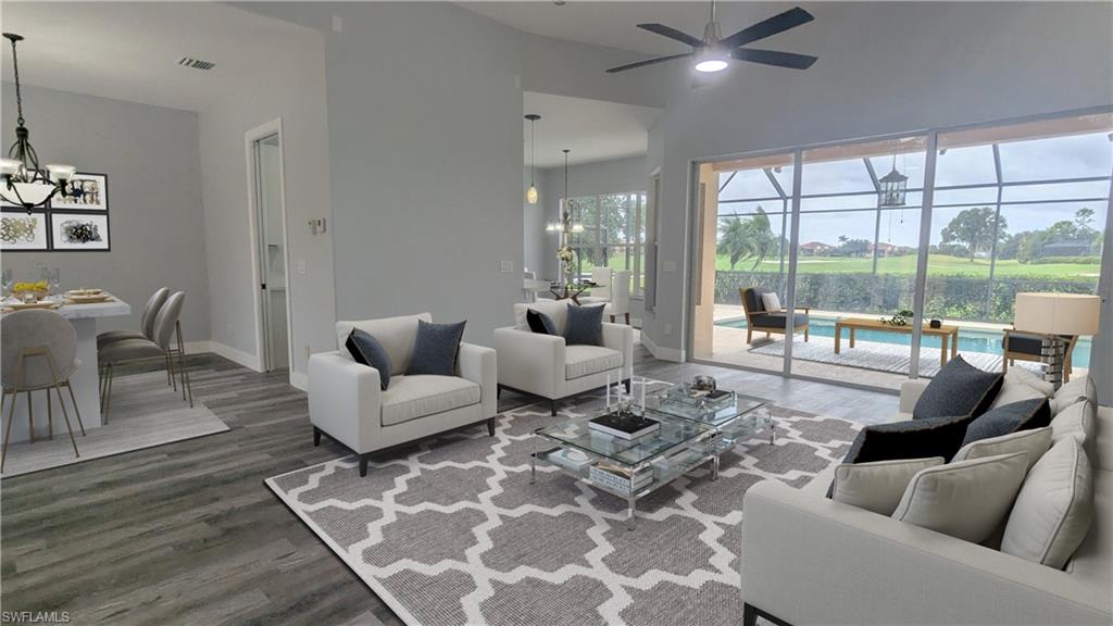 Living room with dark wood-type flooring, vaulted ceiling, and ceiling fan with notable chandelier