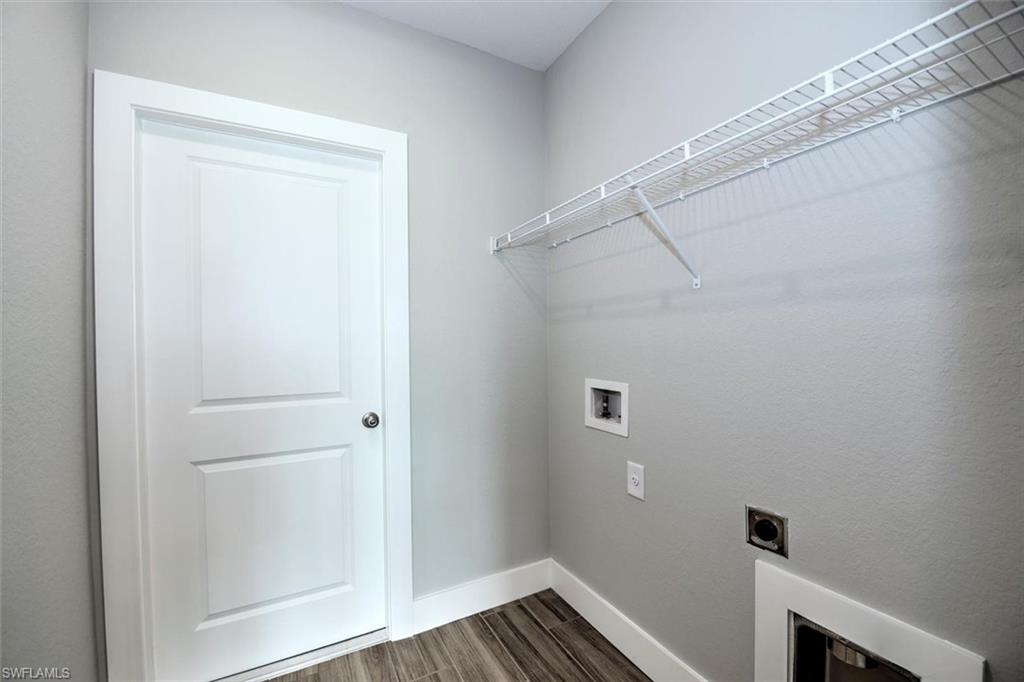 Laundry area featuring dark hardwood / wood-style floors, electric dryer hookup, and washer hookup
