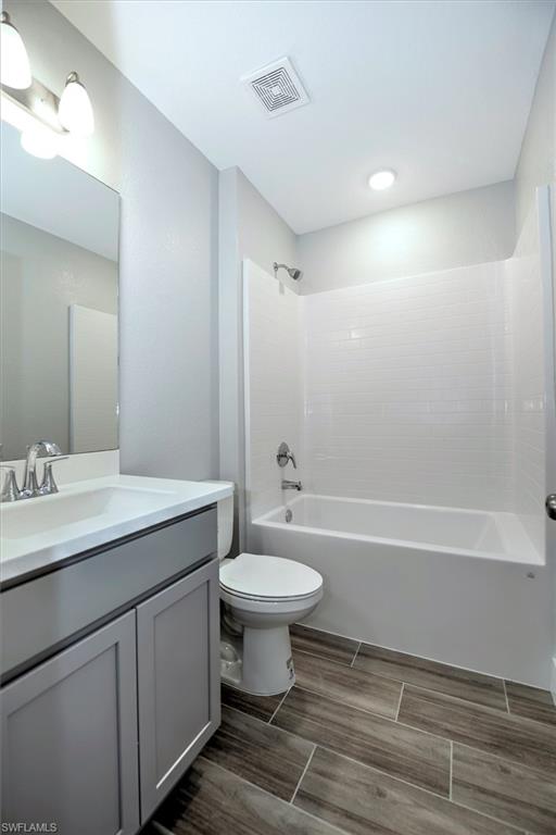 Full bathroom featuring vanity, toilet, and  shower combination