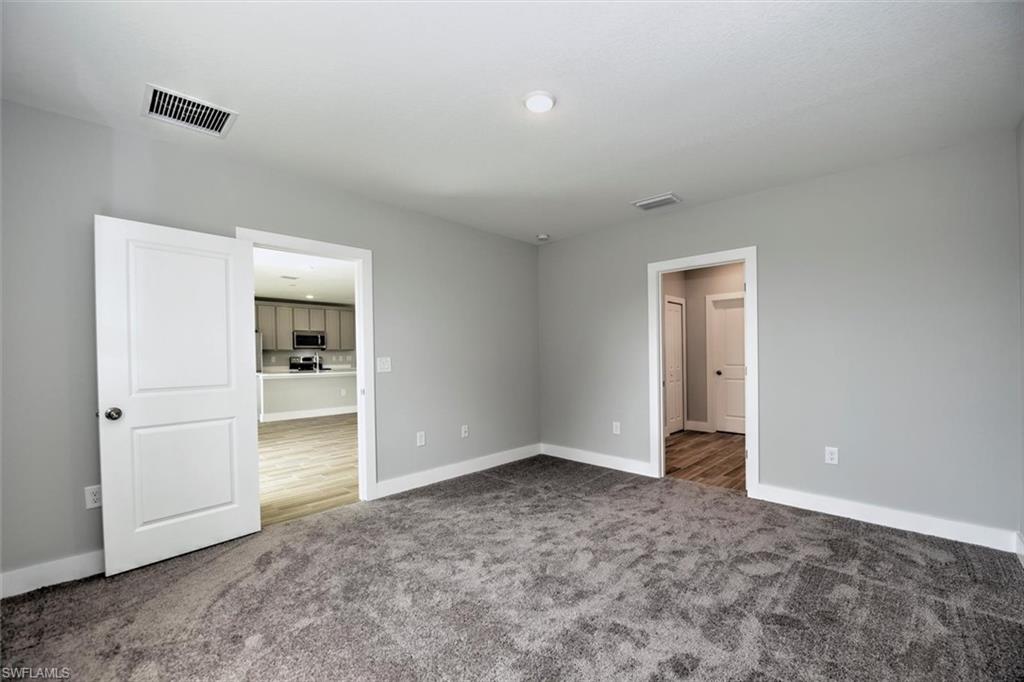 Unfurnished bedroom featuring dark carpet