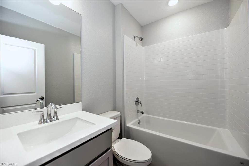 Full bathroom featuring vanity, toilet, and tub / shower combination