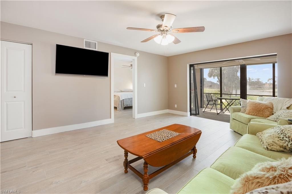 Living room featuring ceiling fan and light hardwood / wood-style floors