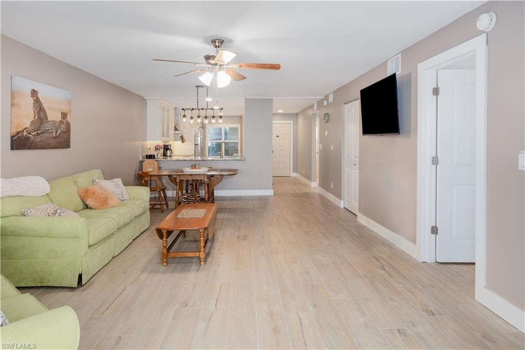 Living room with light wood-type flooring and ceiling fan