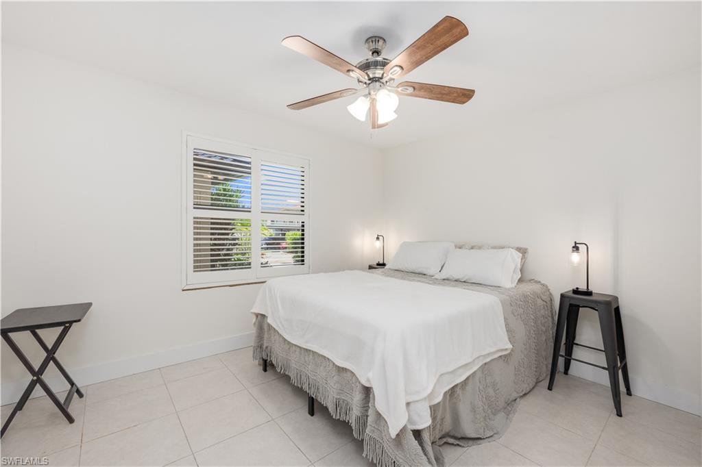 Tiled bedroom featuring ceiling fan