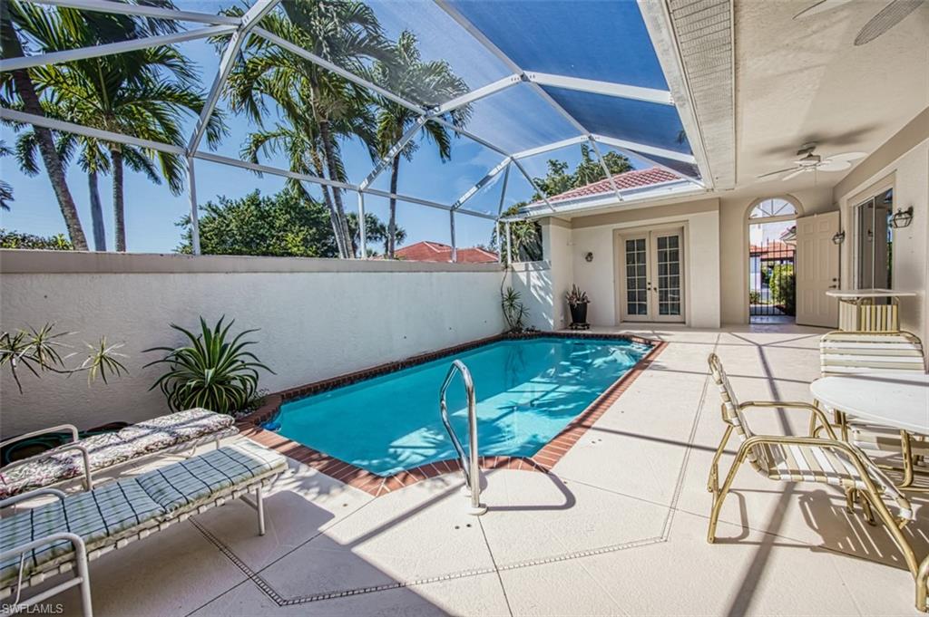 View of pool featuring ceiling fan, a lanai, a patio, and french doors