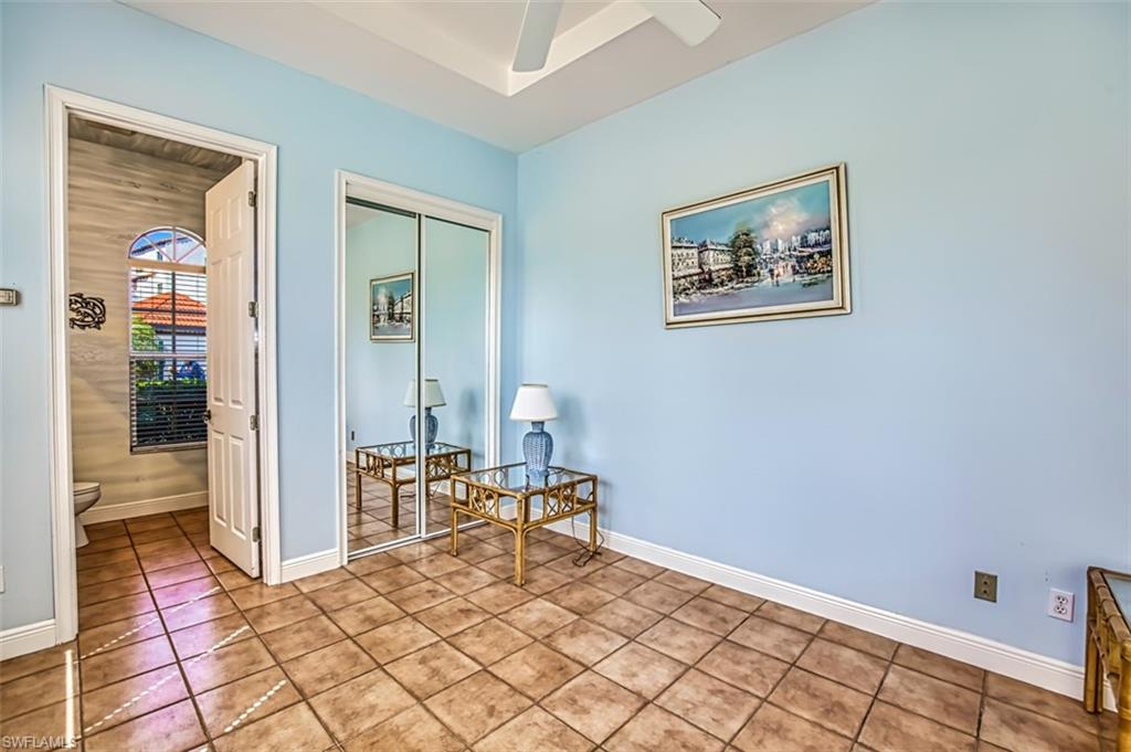 Living area with ceiling fan and light tile patterned flooring