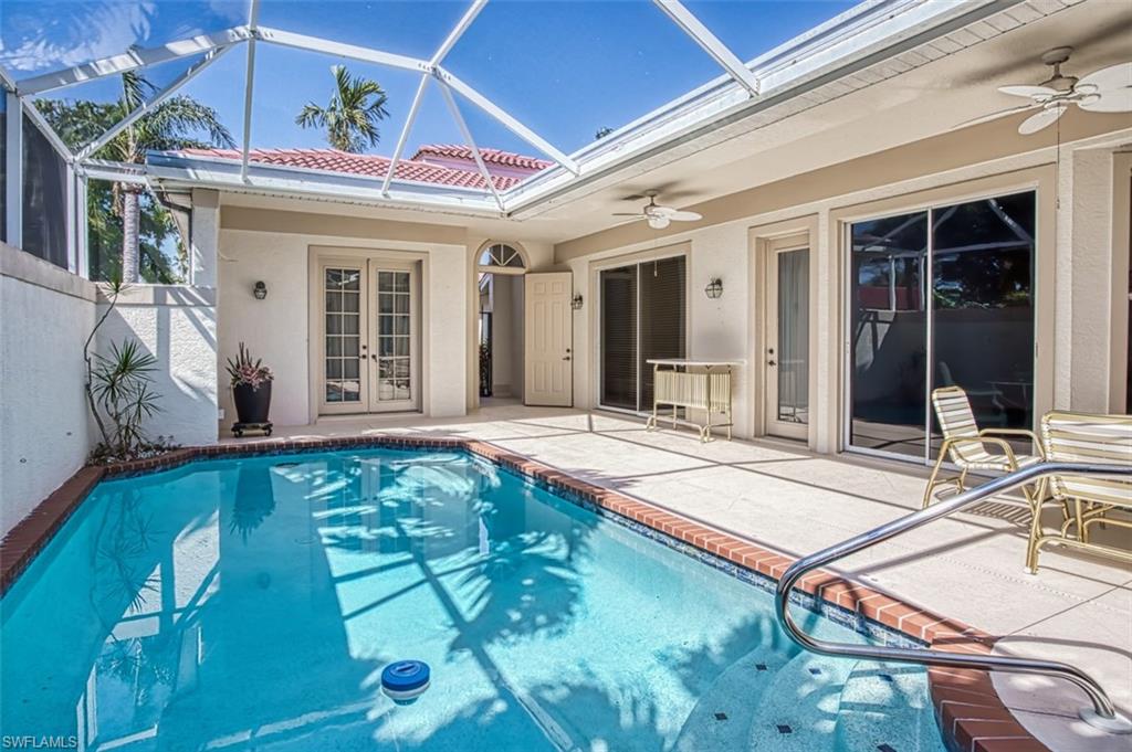 View of pool featuring ceiling fan, a patio area, and glass enclosure