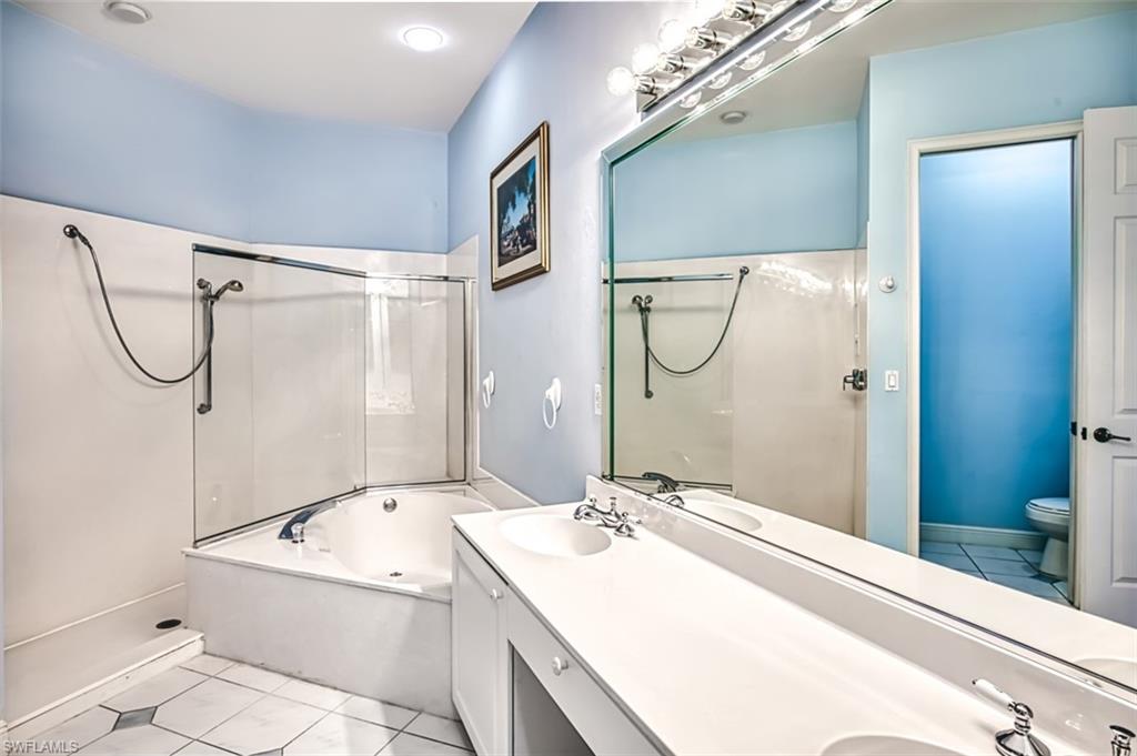 Full bathroom with tile patterned floors, separate shower and tub, toilet, and vanity