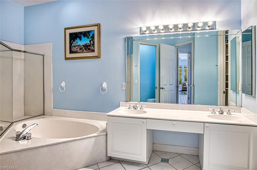 Full bathroom with vanity, toilet, shower with separate bathtub, and tile patterned flooring